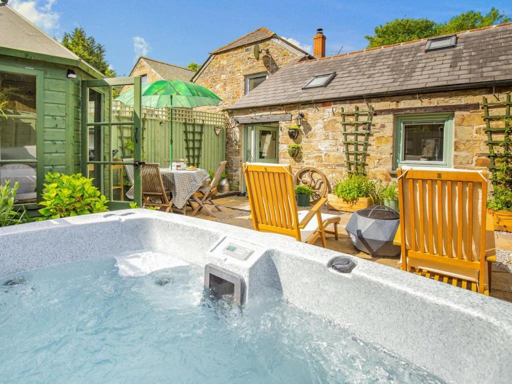 a hot tub in a yard with two chairs at 1 Bed in Bodmin oc-88165 in Bodmin