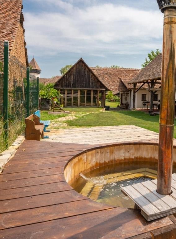 a wooden deck with a fountain in front of a house at Șura din Seleuș - Seleuș Barn - Idyllic Countryside M Museum House in Sighişoara