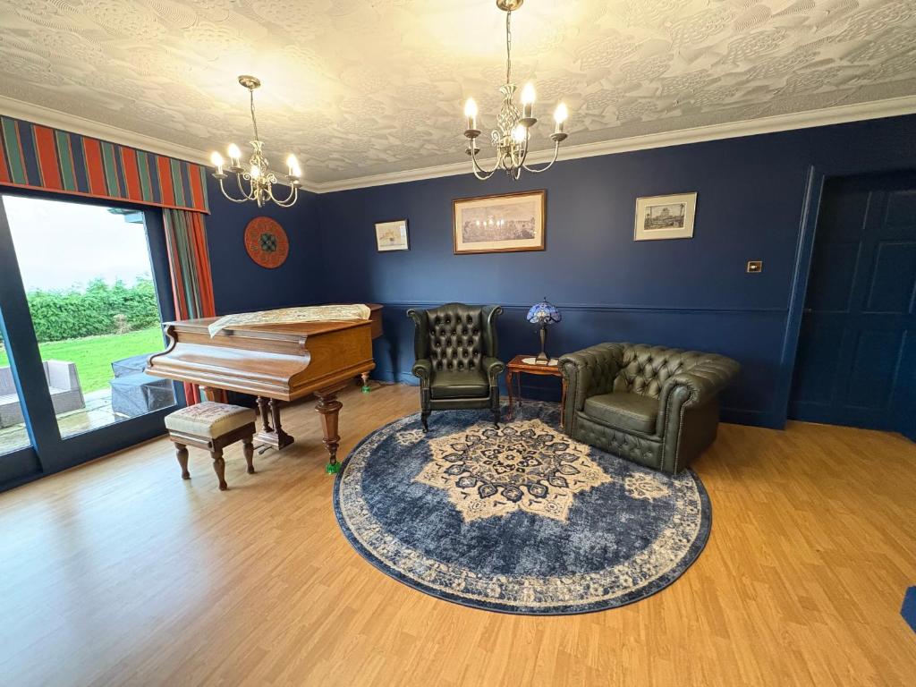 a living room with a piano and a chair at Abalone Accommodation in Culbokie