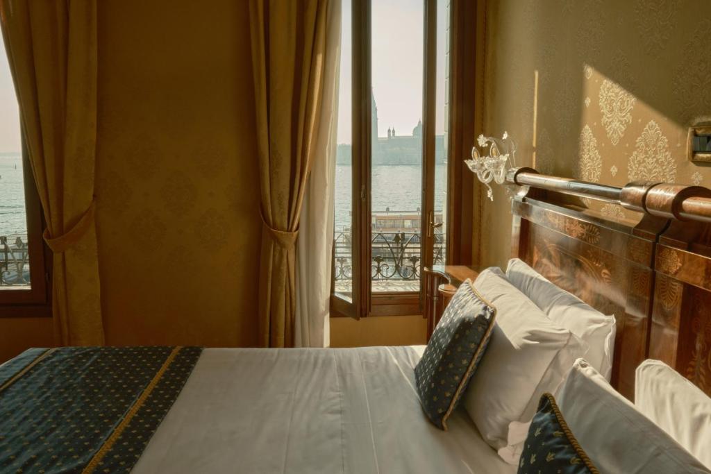 a bedroom with a bed with a view of the ocean at Hotel Pensione Wildner in Venice