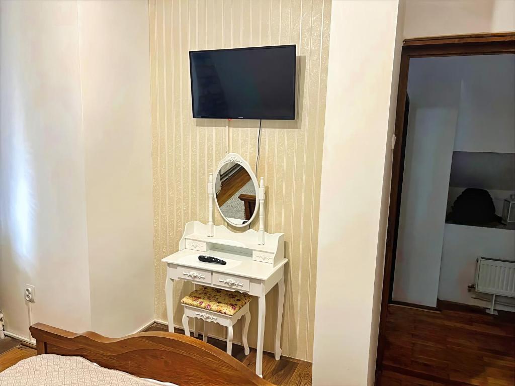 a bedroom with a vanity with a mirror and a tv at Voineasamountainvillas in Voineasa