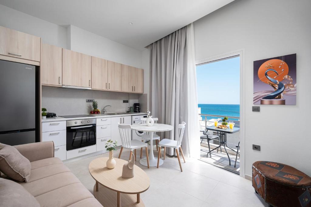 a living room with a couch and a kitchen with a table at Notos Horizon in Ierapetra