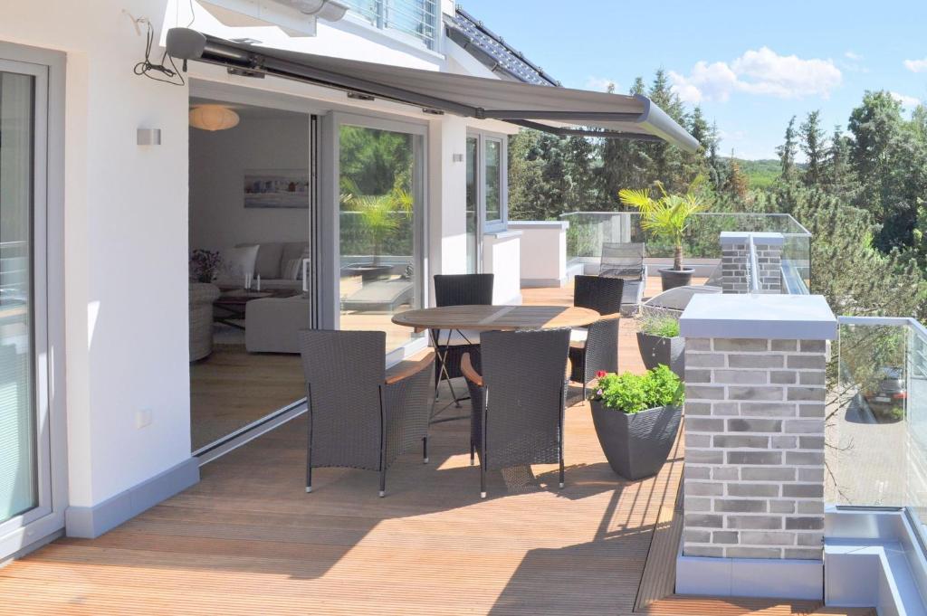 a patio with a table and chairs on a deck at Penthouse am Hafen 2 in Niendorf