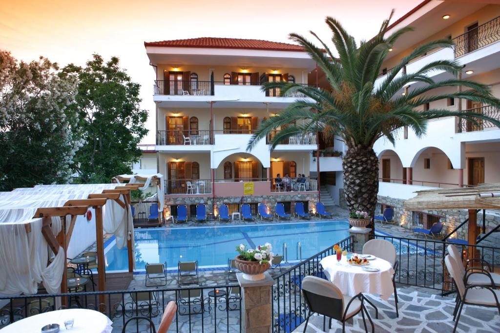 un hotel con una piscina y una palmera en Hotel Calypso, en Chaniotis