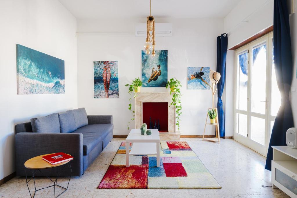 a living room with a blue couch and a fireplace at Dimora Santamarea in Torre Santa Sabina