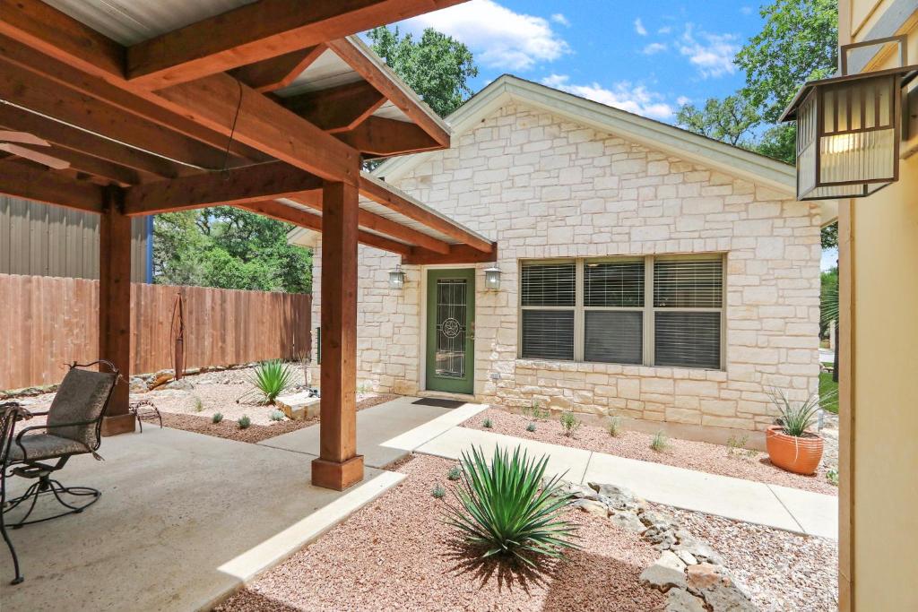 a home with a patio with a wooden pergola at Three Sisters - Casita 2 in Wimberley