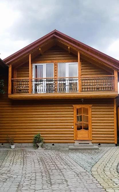 a wooden house with a balcony on top of it at Топірець in Vorokhta