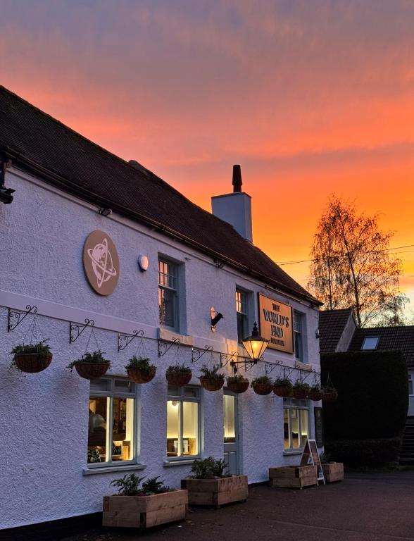 a white building with a sunset in the background at The World's End in Lowdham