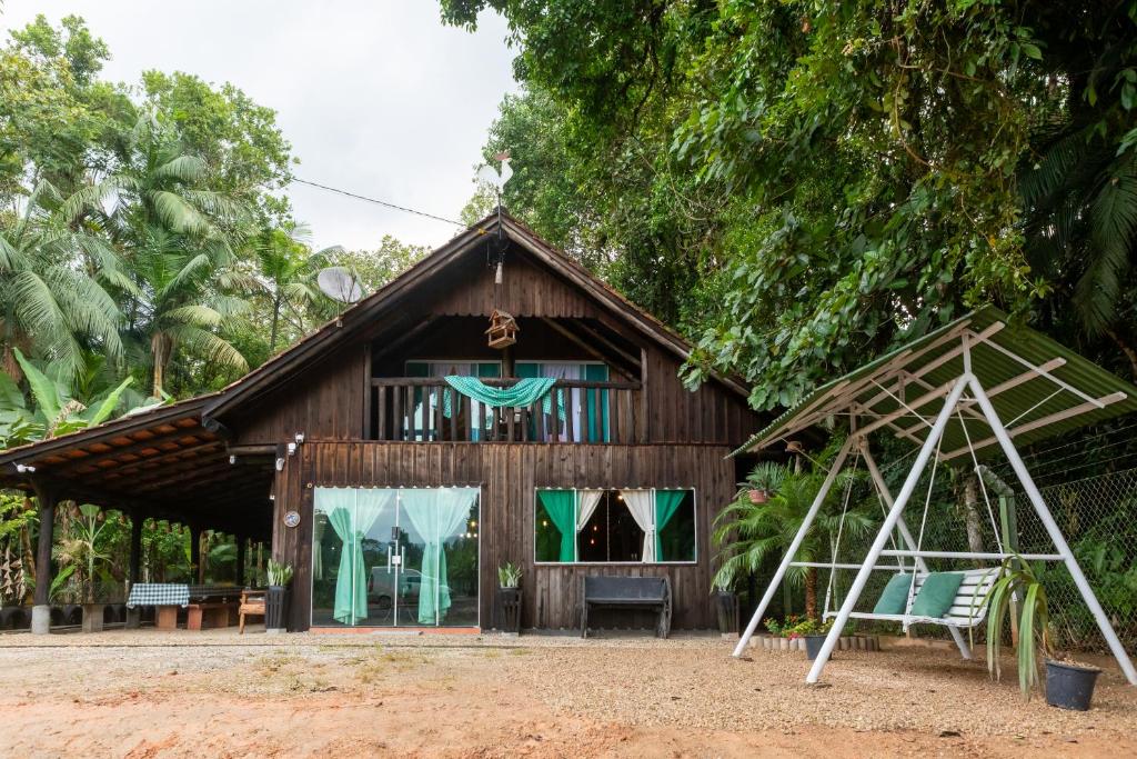 a house with a swing and a playground at Sítio Temporada in Guabiruba