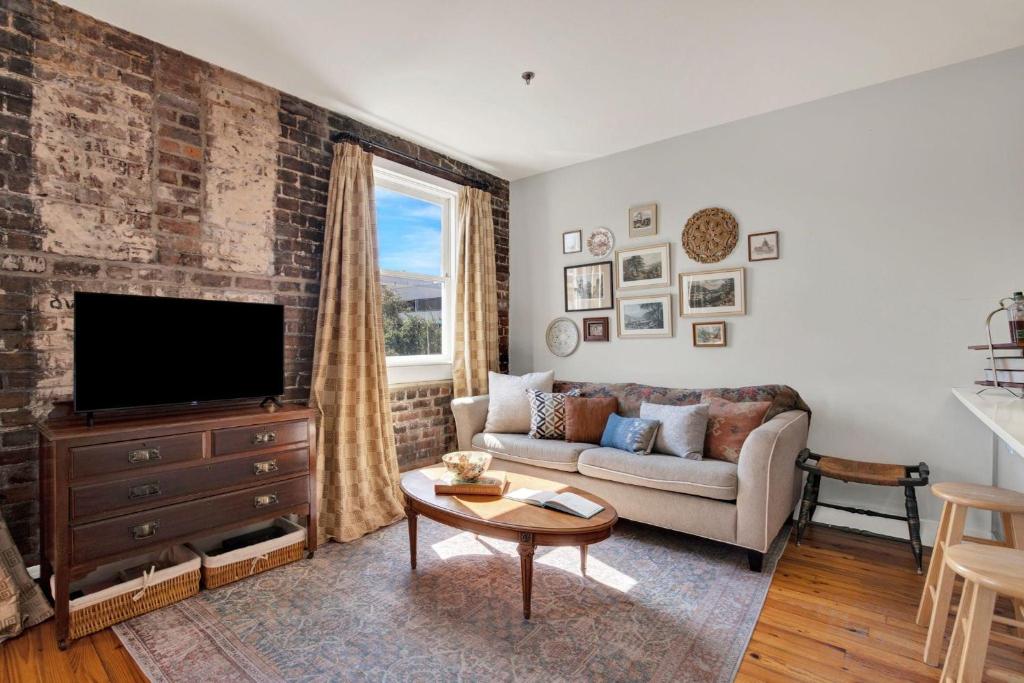 a living room with a couch and a tv at Above Broughton St 3002 in Savannah