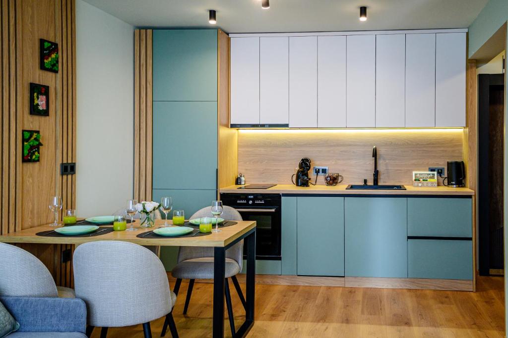 a kitchen with a table and a kitchen with white cabinets at Cozy and Stylish Apartment 3 in Stara Zagora
