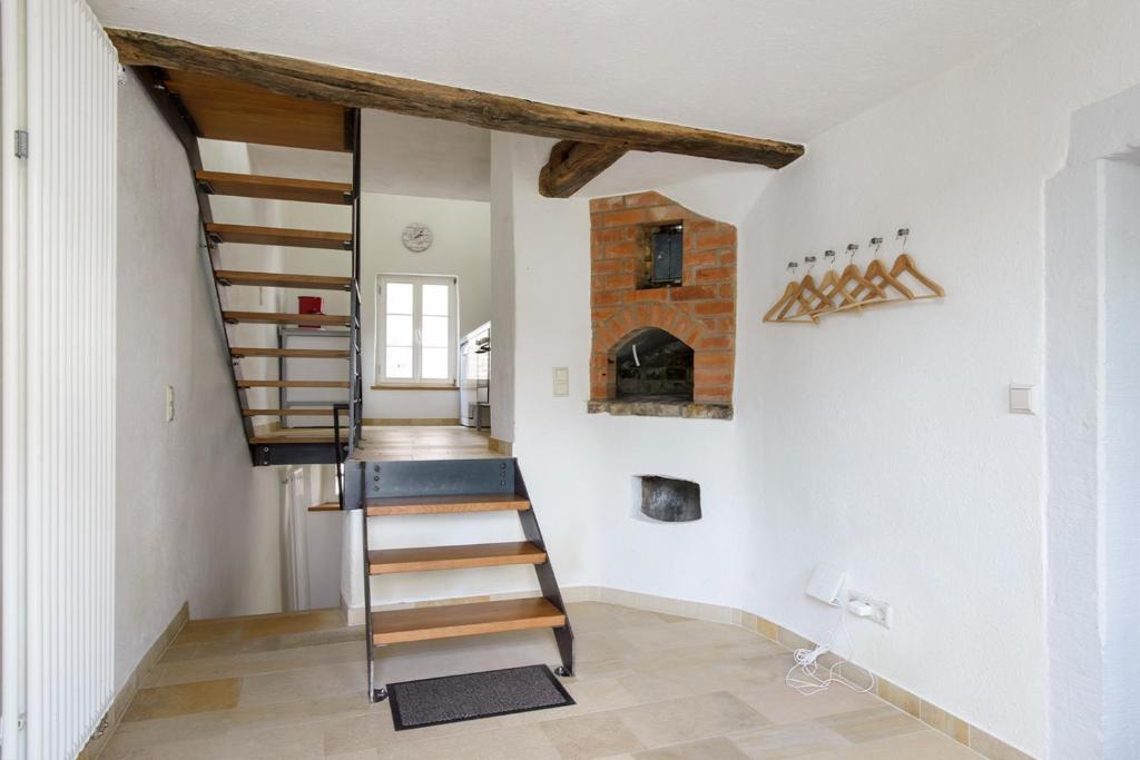 a spiral staircase in a room with a fireplace at Nengshof Ferienhaus Gänseblümchen in Wißmannsdorf