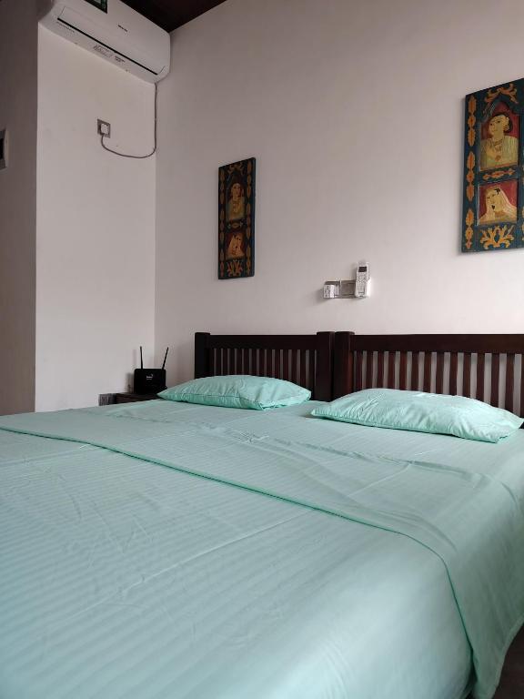 a large white bed with two pillows on it at Harbor View AC Apartment in Ambalangoda