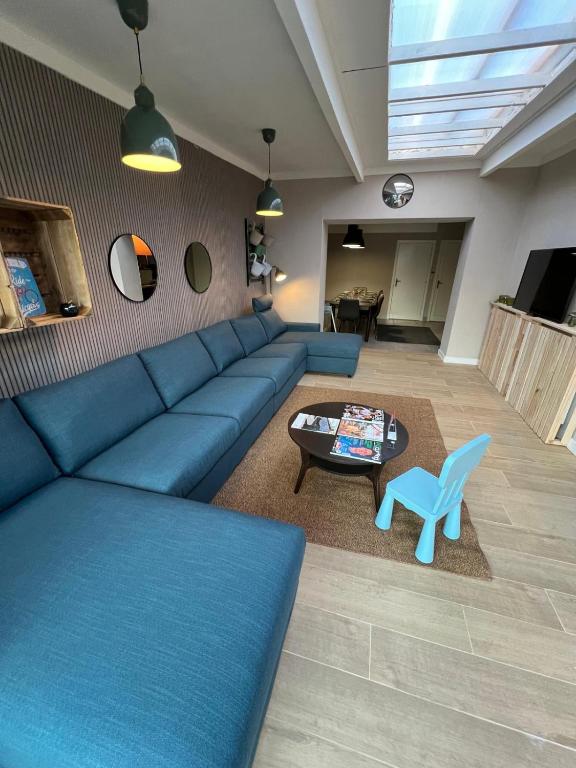 a living room with a blue couch and a table at Vakantiehuis 2 Wheels 2 Relax in Wellen