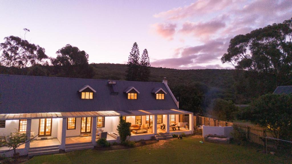 a house with lights on in the evening at Brummer House - Living The Breede in Malgas