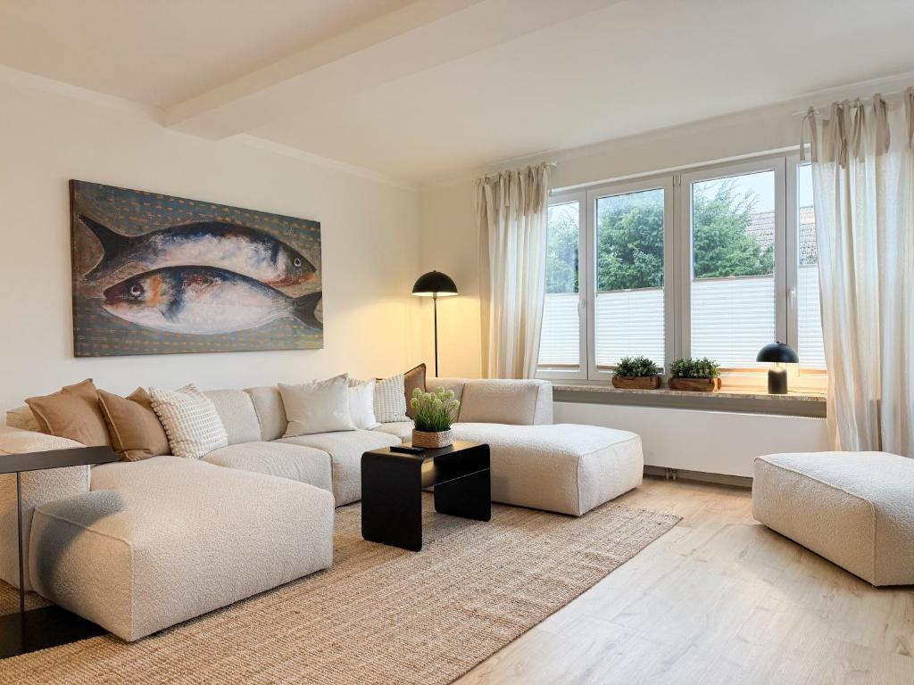 a living room with white furniture and a large window at Cozy Home in Timmendorfer Strand