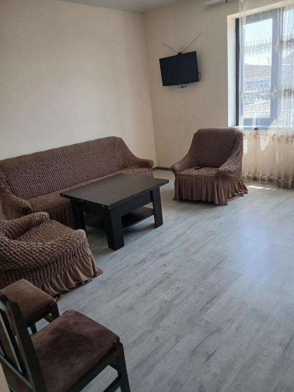 a living room with a couch and a table and chairs at Апартамент in Yerevan