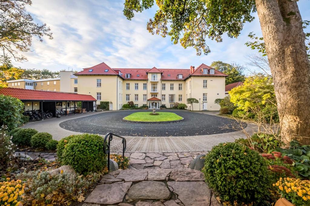 an exterior view of a large building with a circular driveway at Gl Skovridergaard in Silkeborg