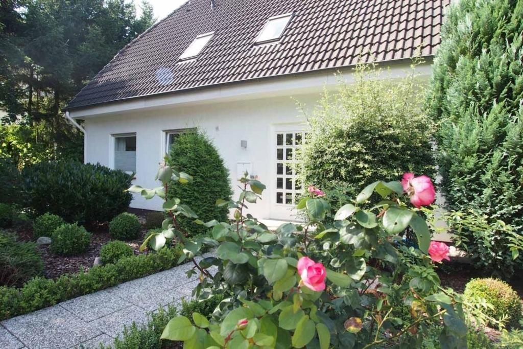 a white house with pink roses in front of it at Weedkroog in Timmendorfer Strand
