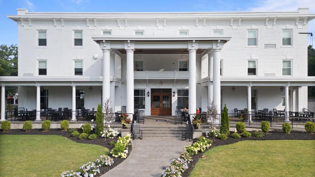 a white building with columns and flowers in front of it at The White Inn in Fredonia