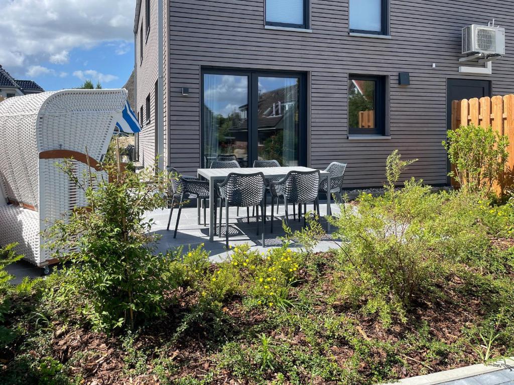 a patio with a table and chairs in front of a house at Hygge Hus 2 in Timmendorfer Strand