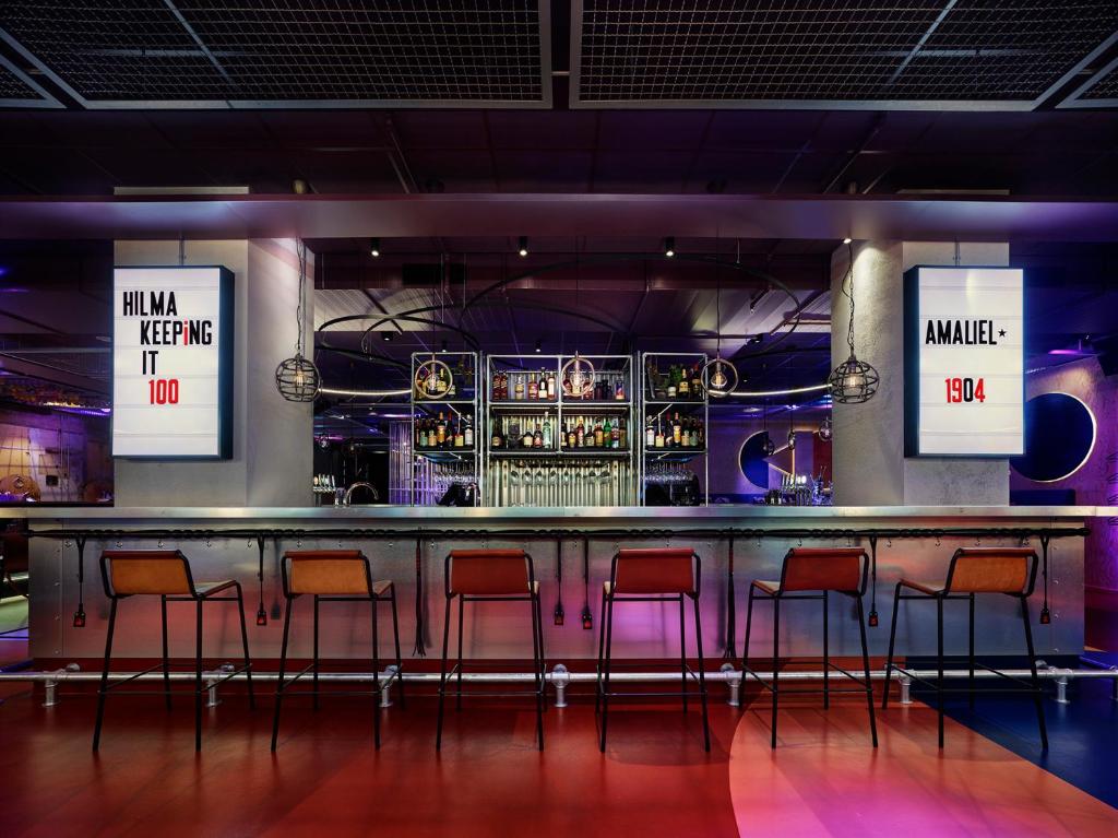 a bar with orange and pink bar stools at Generator Stockholm in Stockholm