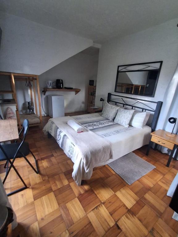 a bedroom with a large bed and a wooden floor at Die Eend Studio in Centurion