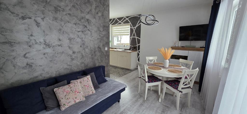 a living room with a blue couch and a table at Apartament Nowe Maniowy in Maniowy