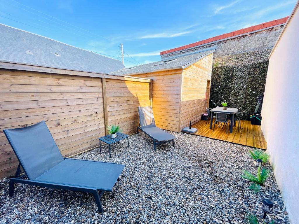 a patio with two chairs and a table and a fence at Les Hirondelles B in Le Crotoy