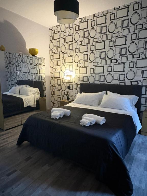 a bedroom with a large bed with two towels at Casa tua suites in Catania