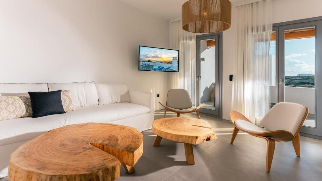 a living room with a white couch and a table at Double Pool Villa Ι in Kampos Paros