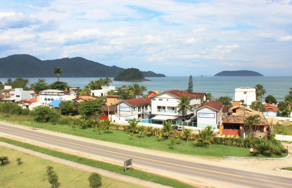 a town with houses and the ocean in the background at Hotel Venice Ubatuba in Ubatuba