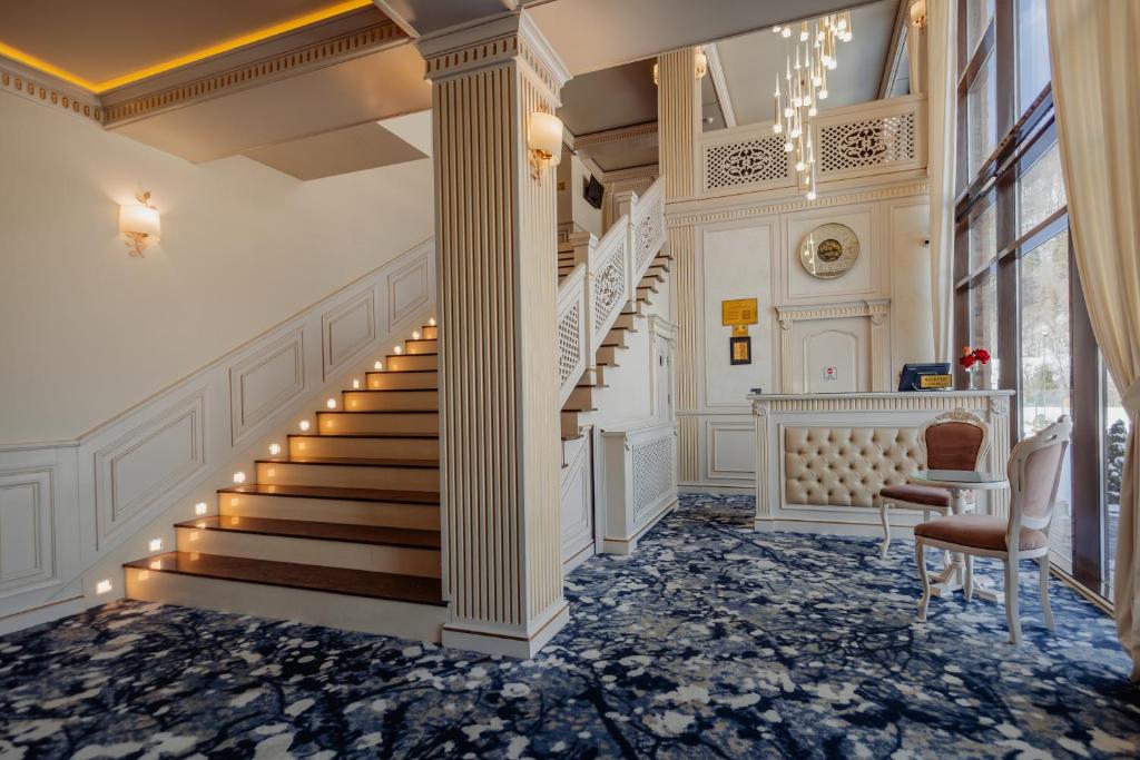 a staircase in a home with columns and a stair case at Grădina Mariajelor Hotel in Câmpulung Moldovenesc