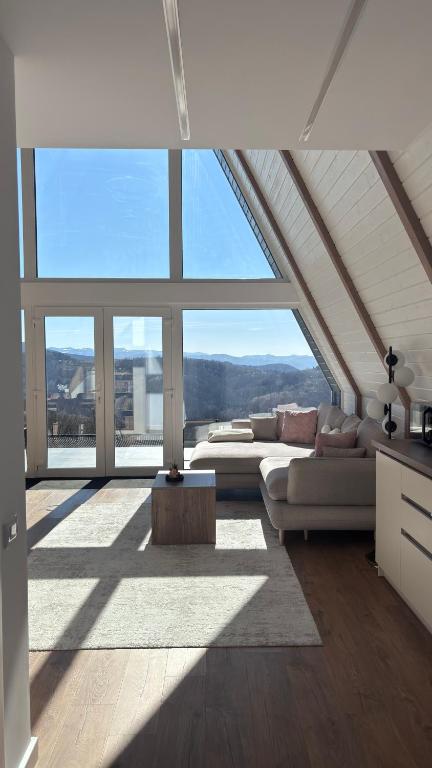 a living room with large windows and a couch at Air Cabin A2, A-frame Șerani, Bihor in Şerani