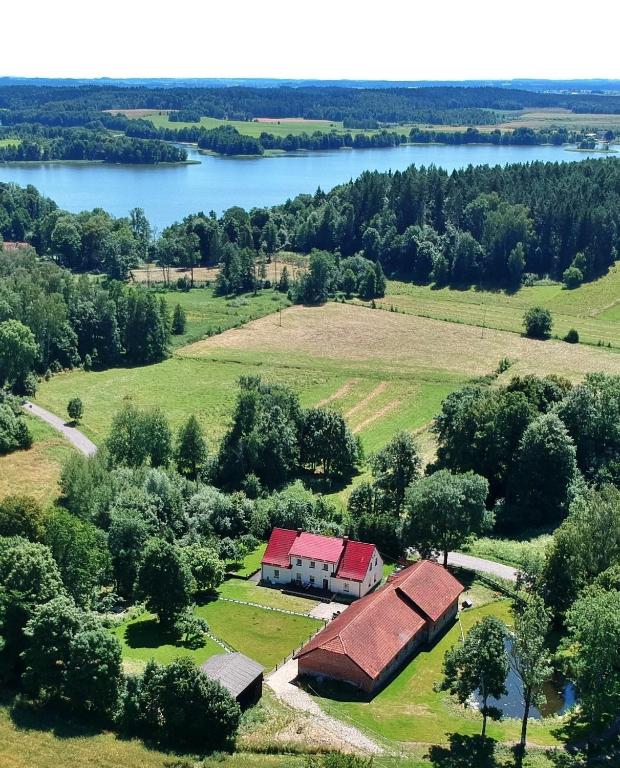 an aerial view of a farm with a barn and a lake at Folwark Mazurskie Legendy - Azyl dla Dorosłych in Kruklanki