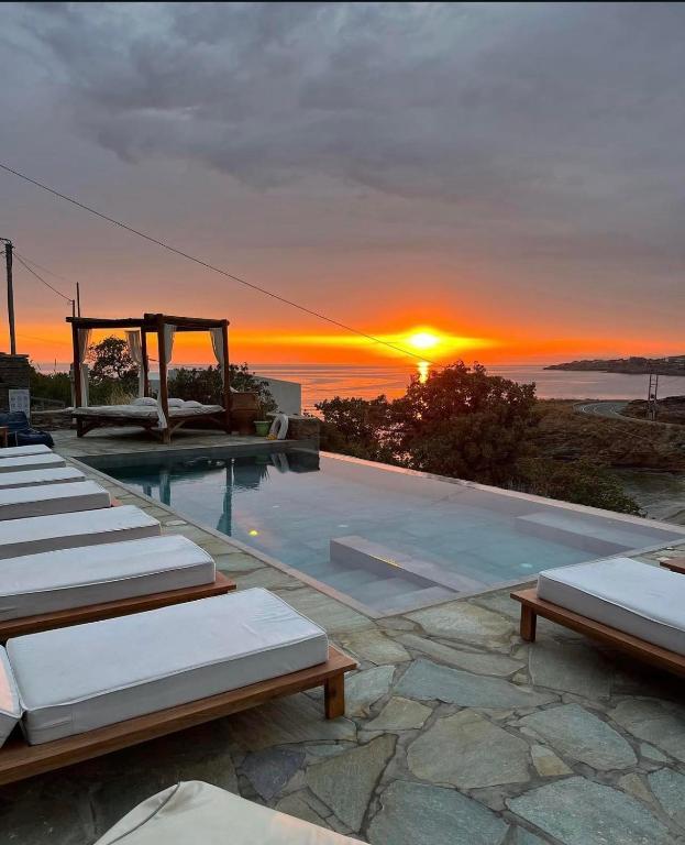 a swimming pool with a sunset in the background at Iris villa in Koundouros