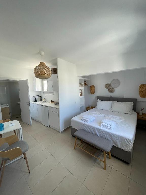 a bedroom with a large bed and a kitchen at CHORA NEST KYTHNOS in Kithnos