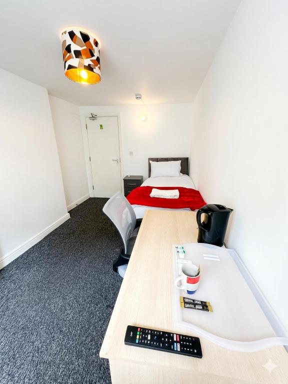 a room with a bed and a desk with a keyboard at Macclesfield Lodge in Macclesfield