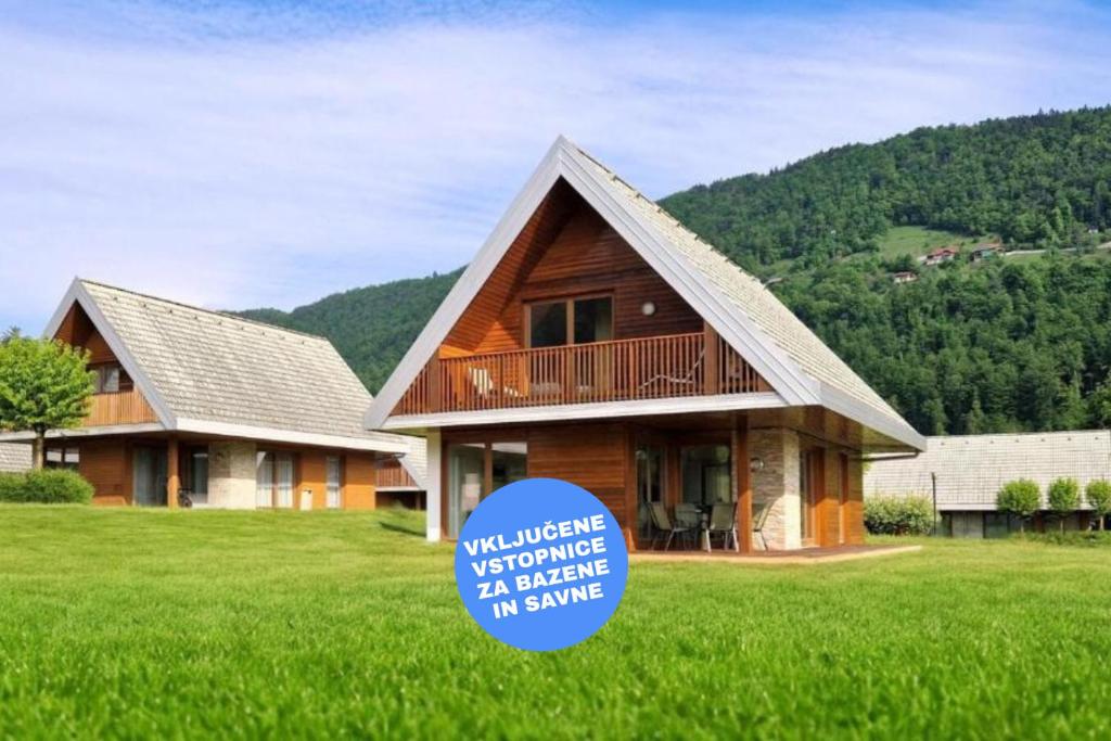 a house in a field with a sign in the grass at Apartment HORTENZIJA near Terme Topolšica in Topolšica