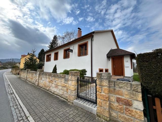 a small white house behind a stone wall at Nicole in Hartau