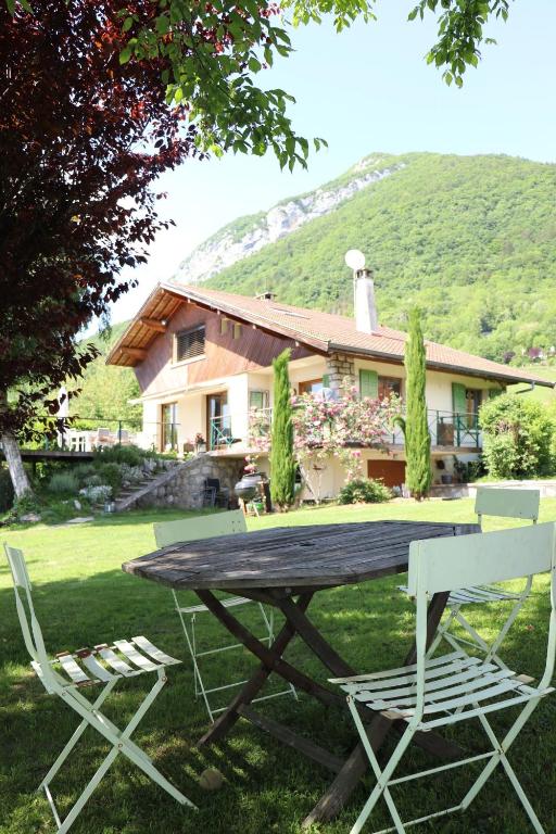 a picnic table and chairs in front of a house at Villa Crysaële in Menthon-Saint-Bernard