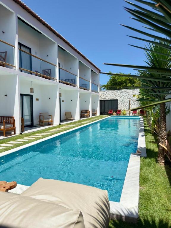 an image of a swimming pool in front of a building at Yahweh Hotel in São Miguel do Gostoso