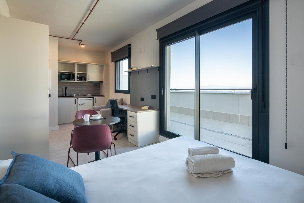 a room with a bed and a kitchen with a large window at Codomo Living Granada in Granada