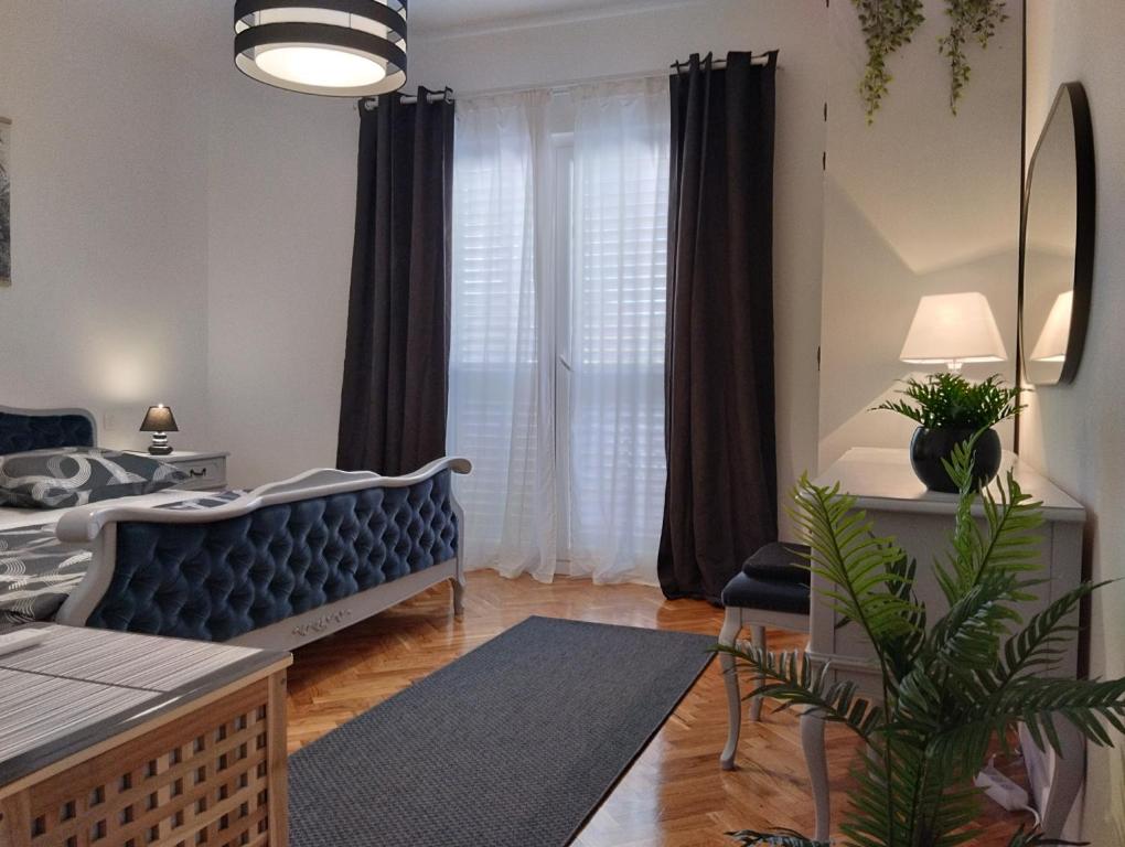 a living room with a blue couch in front of a window at Keti House Rooms in Vela Luka