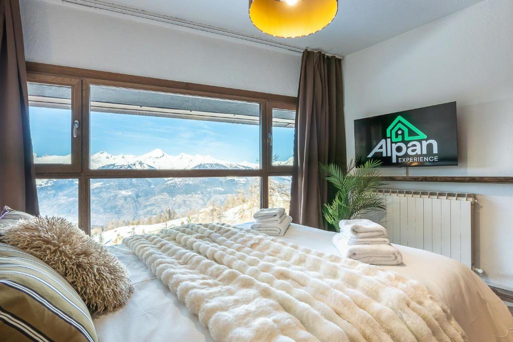 a large bed in a room with a large window at ALPHIRA - Vista Montagne e Deposito per Sci e Bici in Pila
