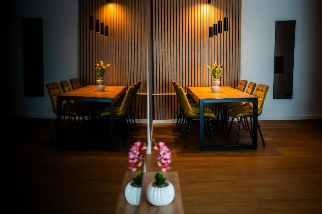 two tables in a room with chairs and flowers at Elite Luxury Crib in Cluj-Napoca
