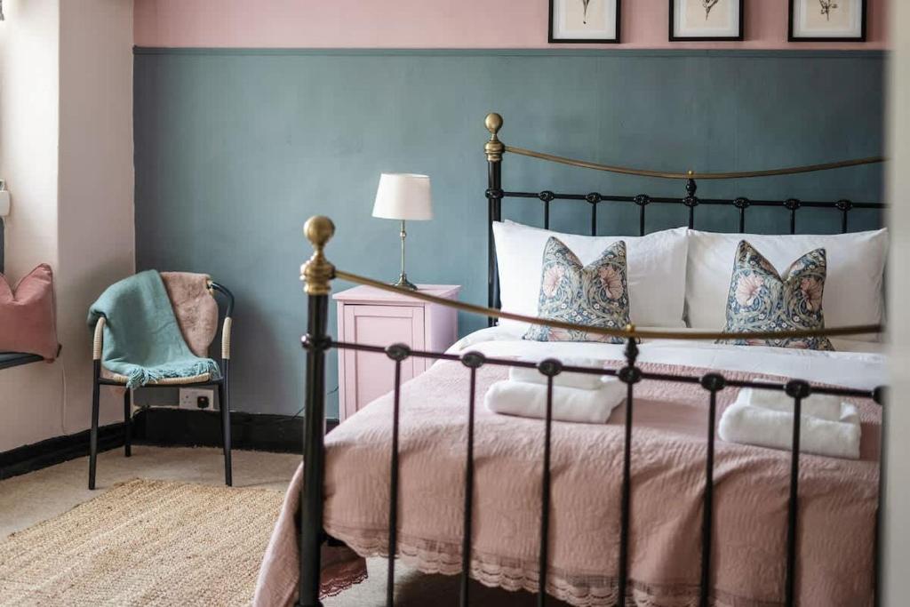a bedroom with a bed and a chair at Redesdale View, High Street with Private Garden in Moreton in Marsh