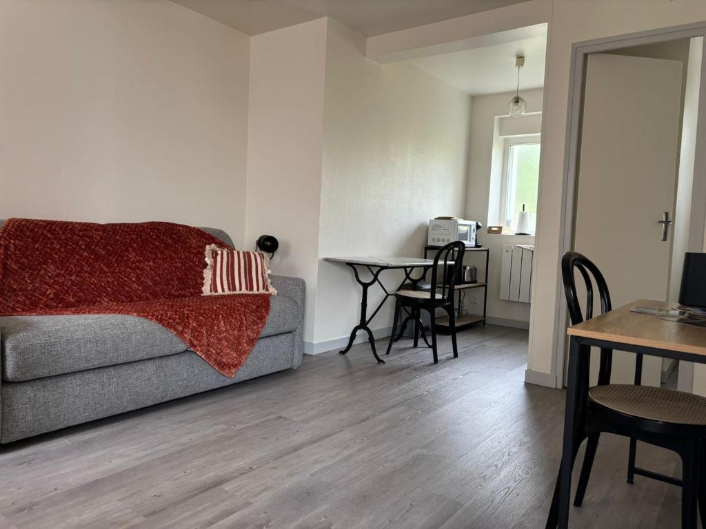 a living room with a couch and a table at Sur Egletons - Le Cocon Egletons in Égletons