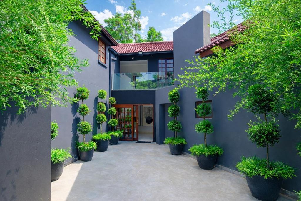 a courtyard with potted plants in front of a building at Apple Blossom Hotel Portfolio in Roodepoort