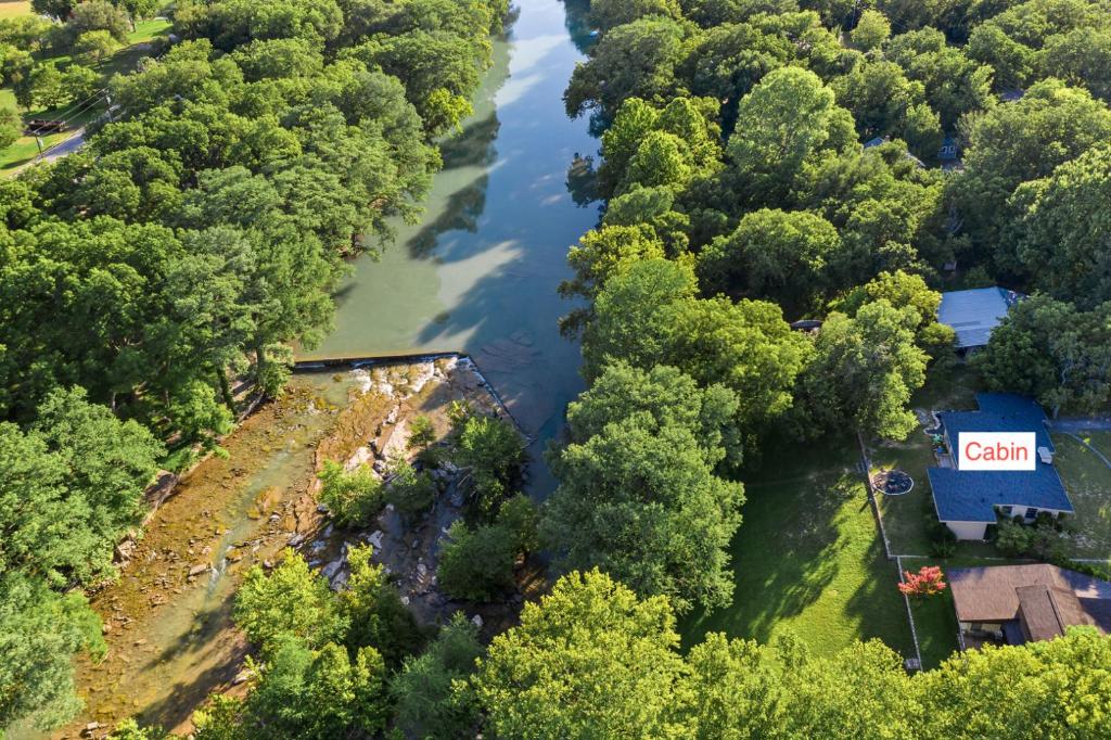 an aerial view of a river with a house and trees at Stone River Cabin in Canyon Lake